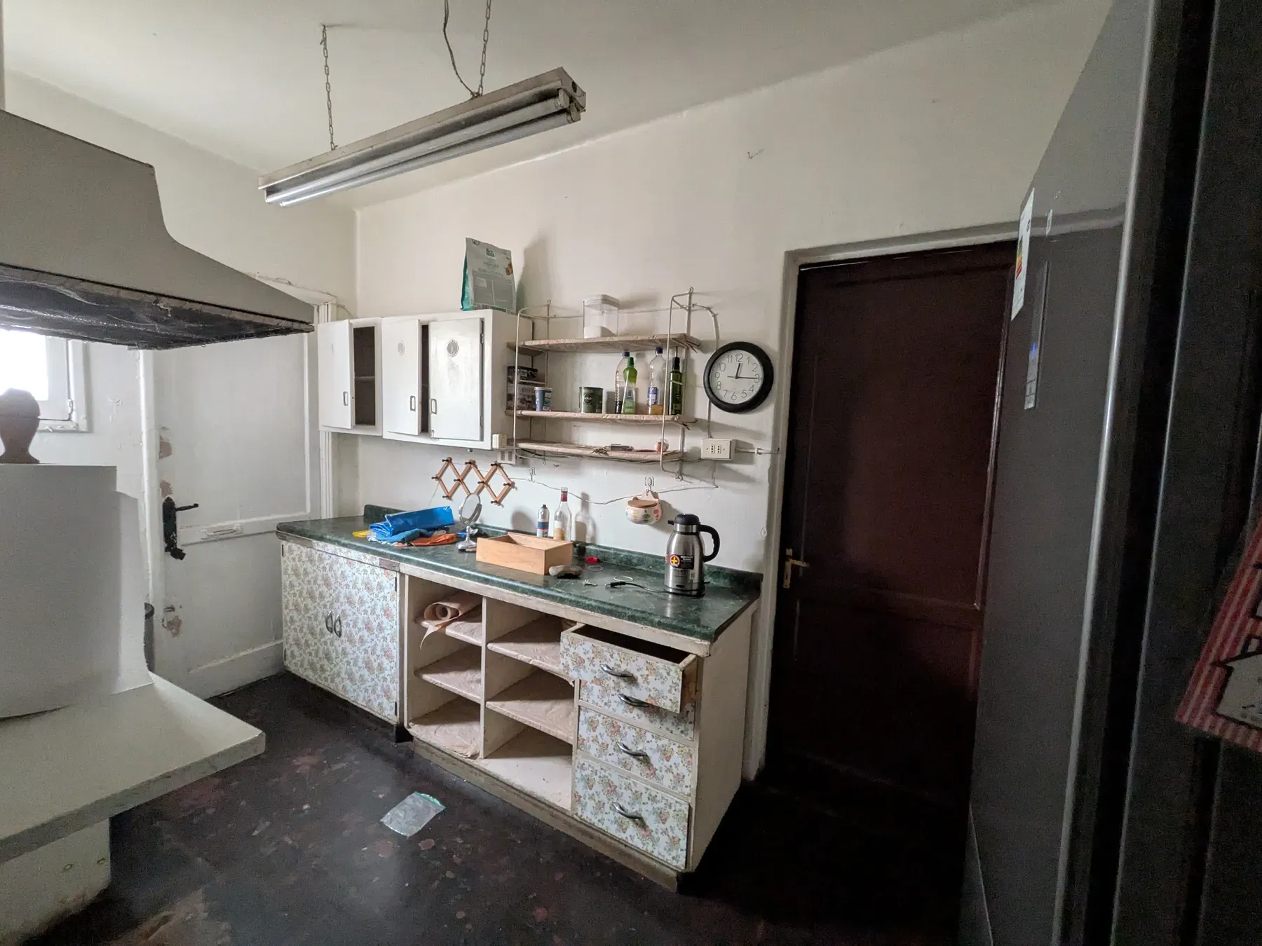 La cocina original, con los muebles forrados, la cubierta antigua y el tubo fluorescente colgando