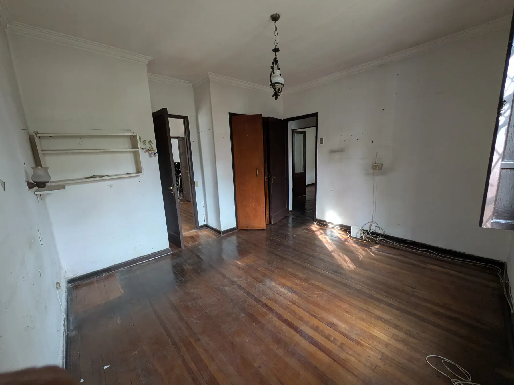 Recinto interior antes de la obra, con el parquet gastado y los muros manchados