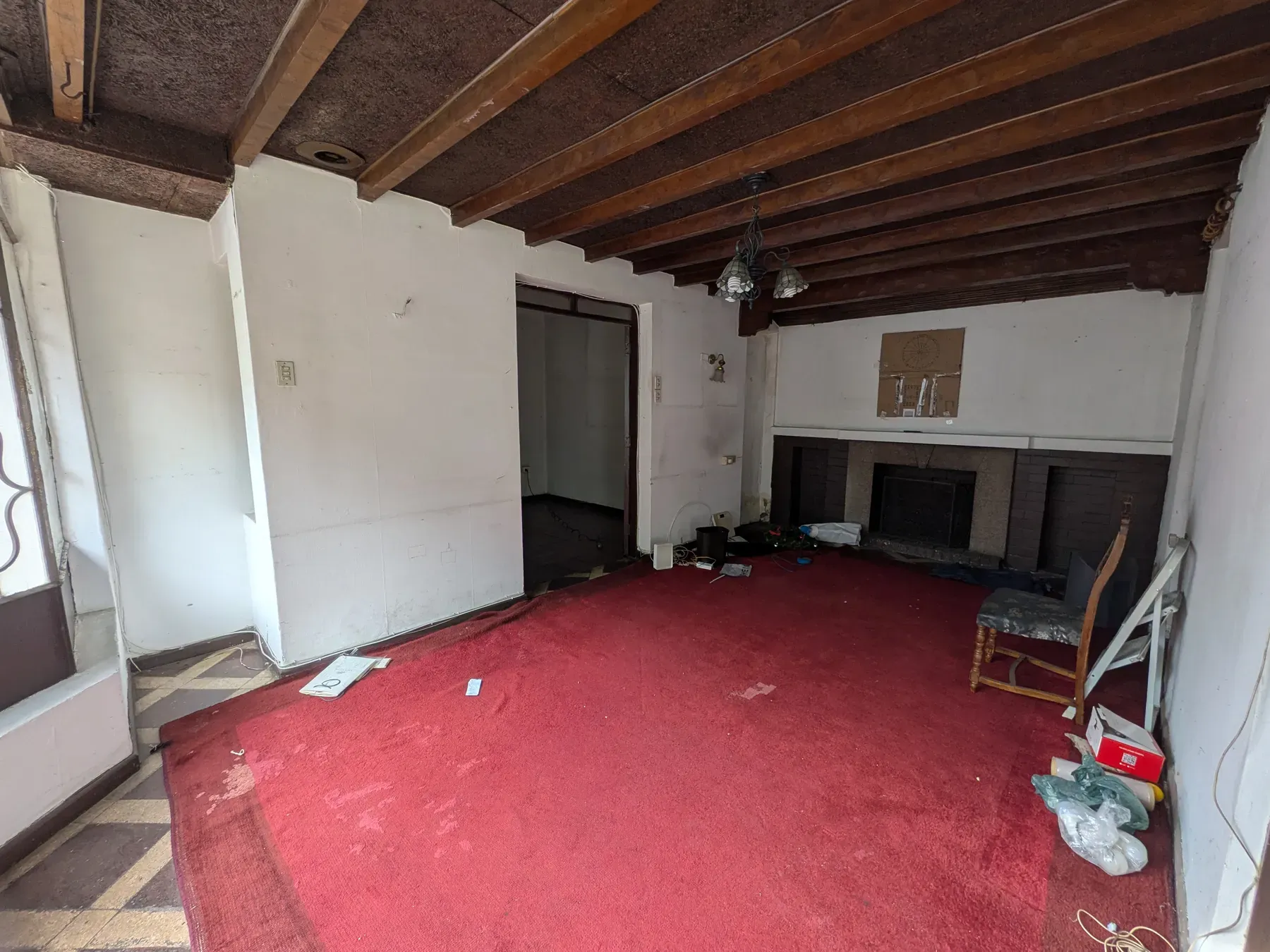 Dormitorio con alfombra roja y el entramado de madera del cielo a la vista