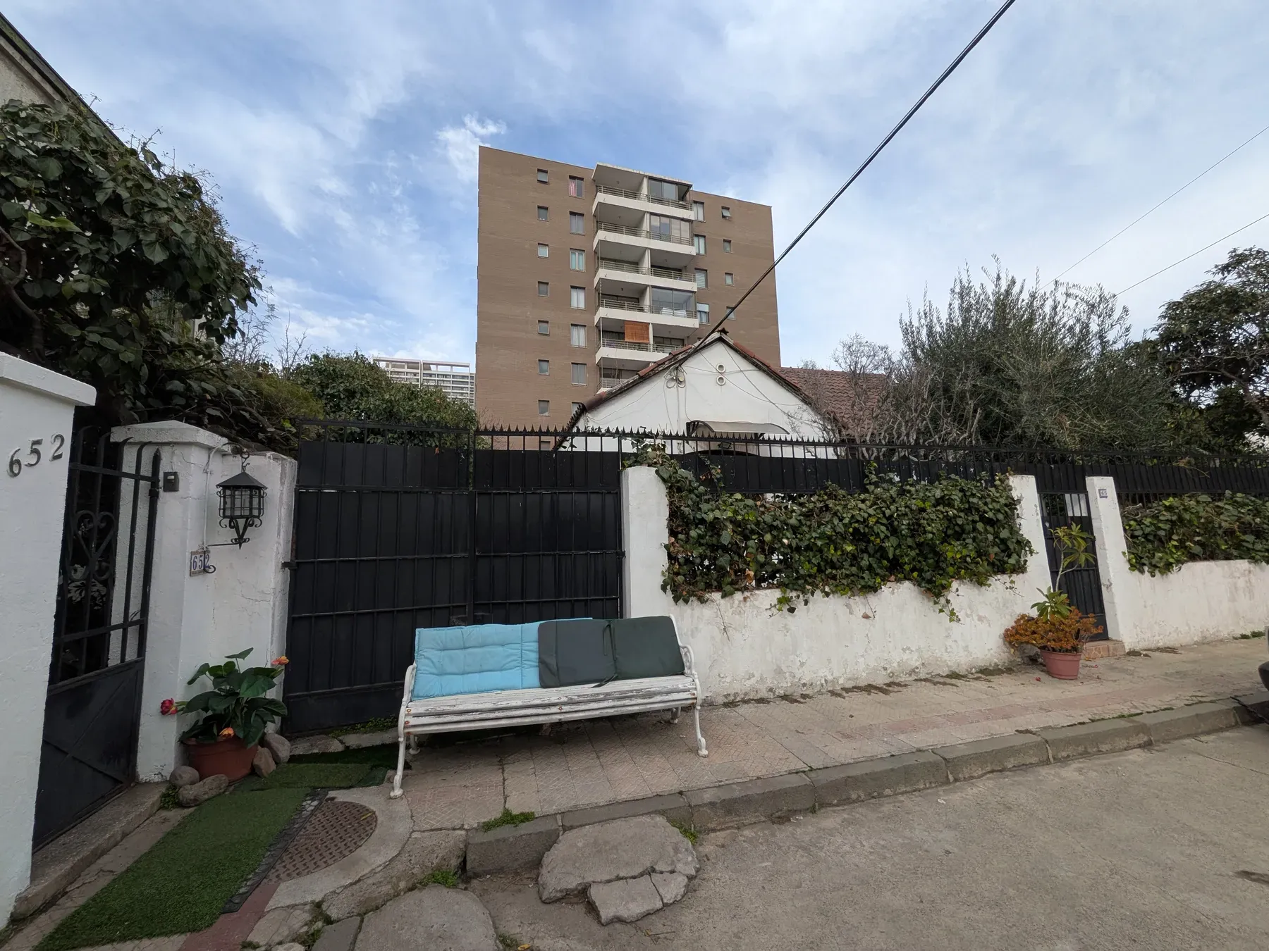 La casa desde la calle antes de la obra, con el muro y el portón deteriorados