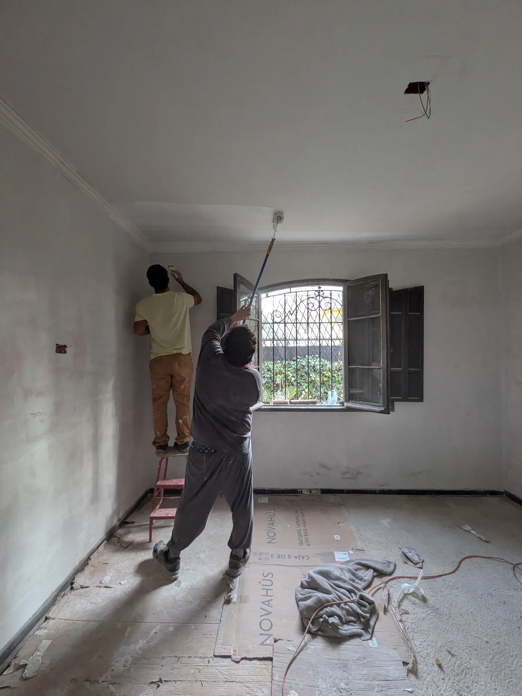 Maestro trabajando el muro de un recinto ya despejado, junto a la ventana