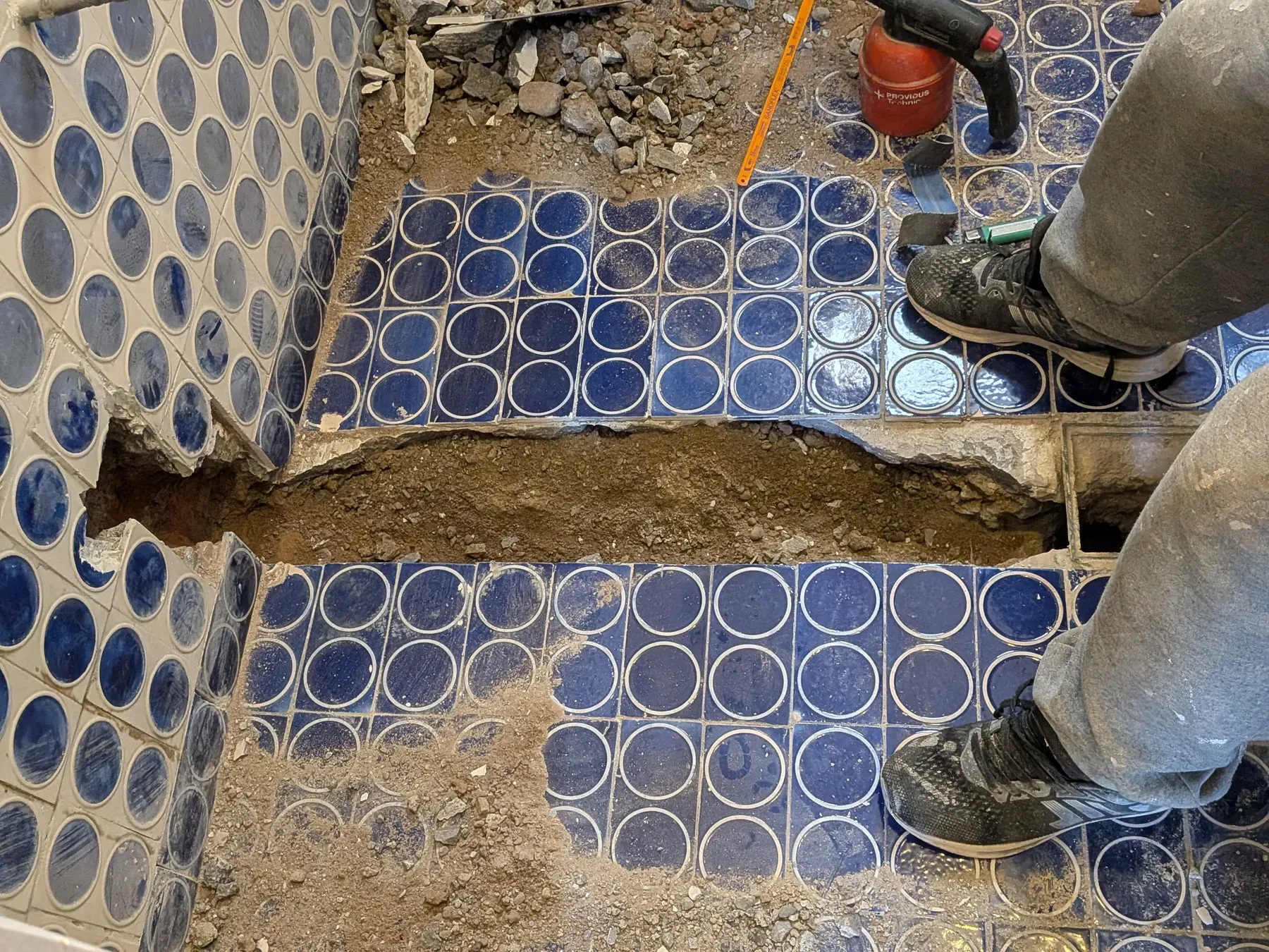 Instalación del mosaico azul en el piso y el muro del baño