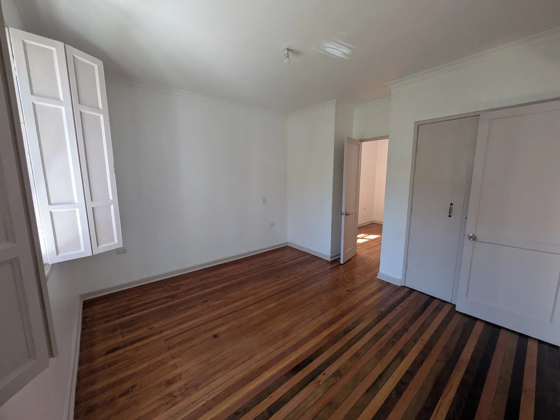 Dormitorio con el parquet reparado y lijado, y los muros ya pintados