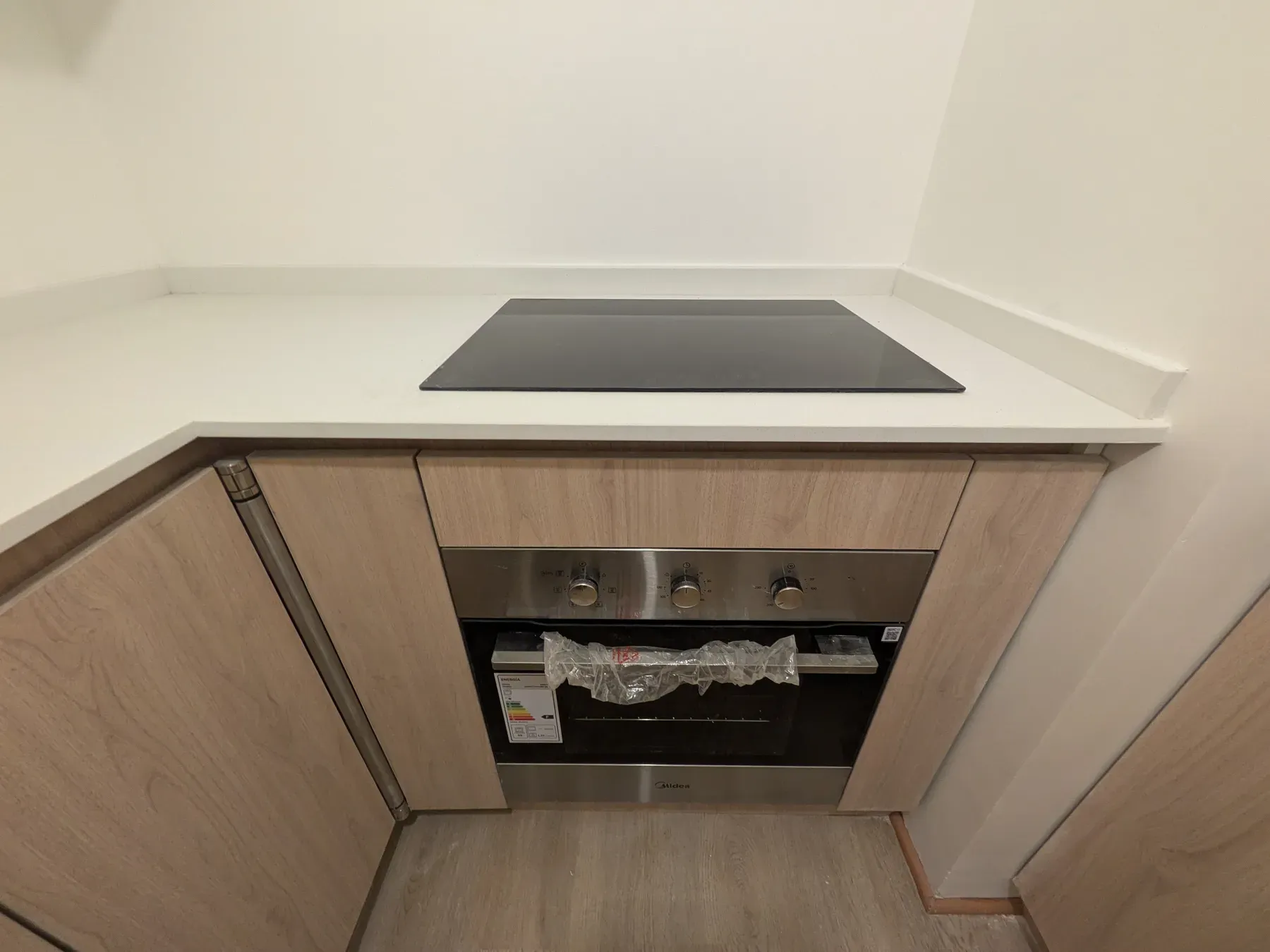 Encimera de inducción y horno empotrado en el mueble bajo