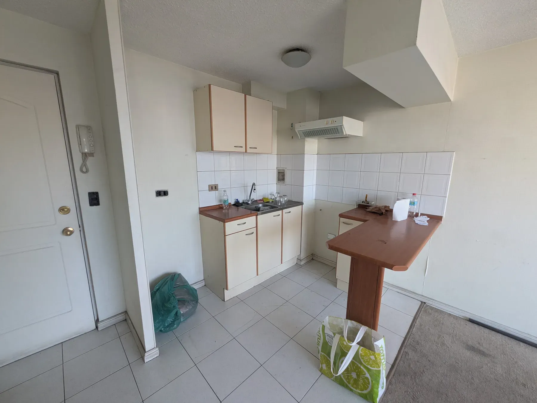 Cocina original del departamento, con cerámica blanca y muebles de melamina antiguos