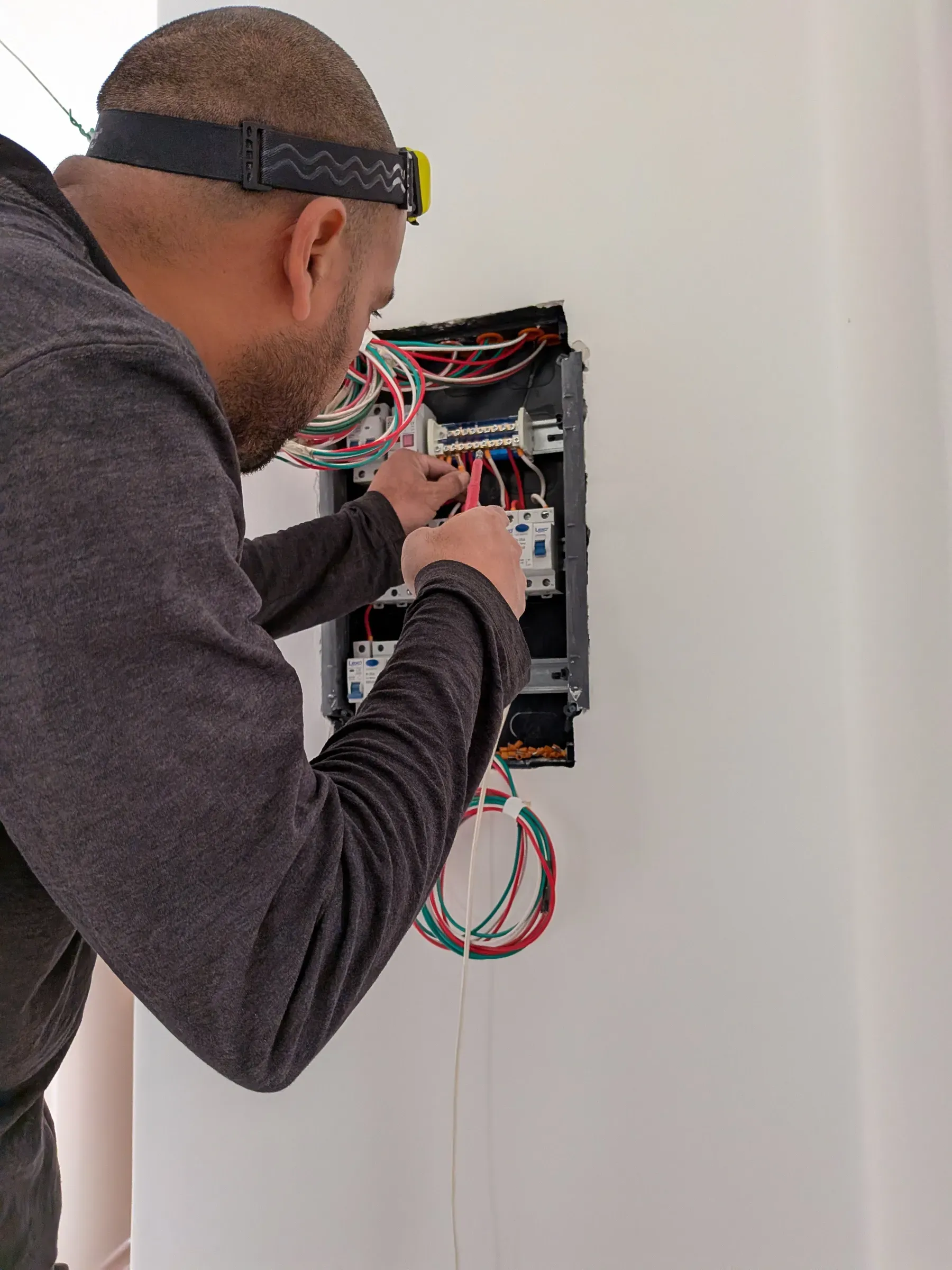 Maestro eléctrico conectando los automáticos de un tablero