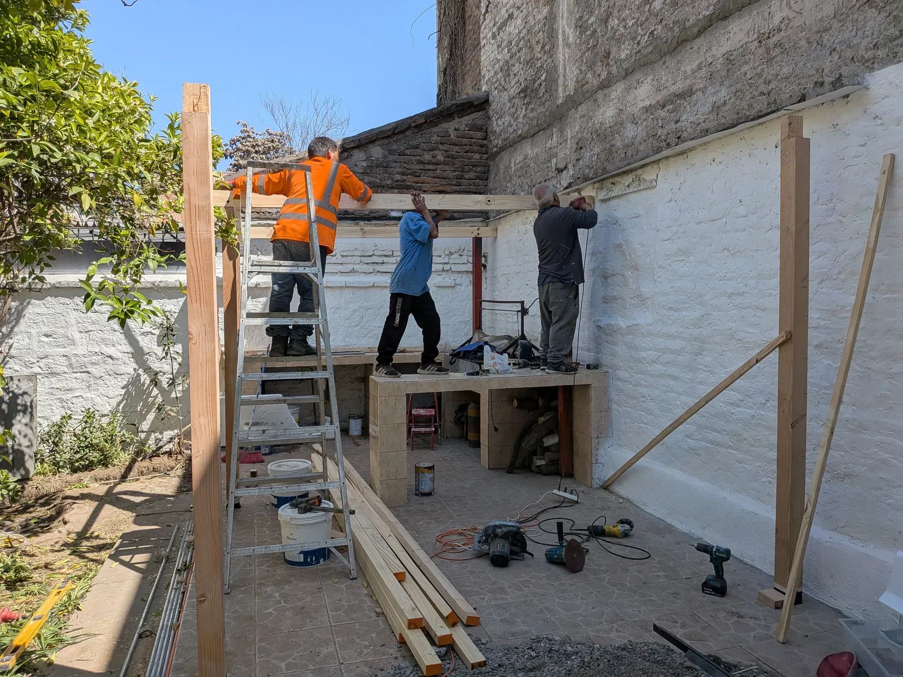 Equipo trabajando sobre andamio en la fachada de una vivienda